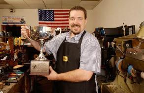 Larry Schupbach holding the 2003 Grand Silver Cup, awarded by the Shoe Service Institute of America.